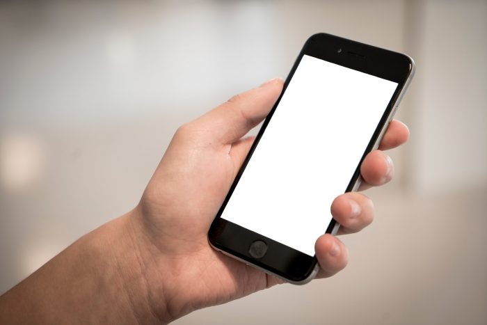 Smartphone Displayschutz: Person hält ein Handy mit einem weißen Display in der Hand. Bild: Pexels
