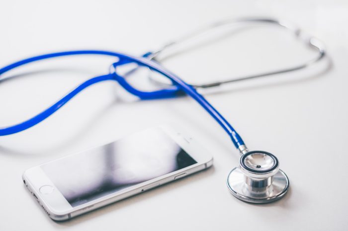 Ein Handy und ein Stethoskop sind auf dem Bild zu sehen. Sie symbolisieren das Krankschreiben lassen per WhatsApp. Foto: Pixabay