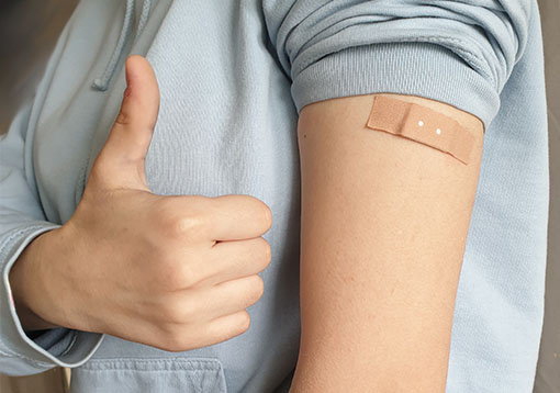 Impfpass-Bilder: Arm mit Pflaster und Daumen-hoch-Geste. Bild: PC-SPEZIALIST