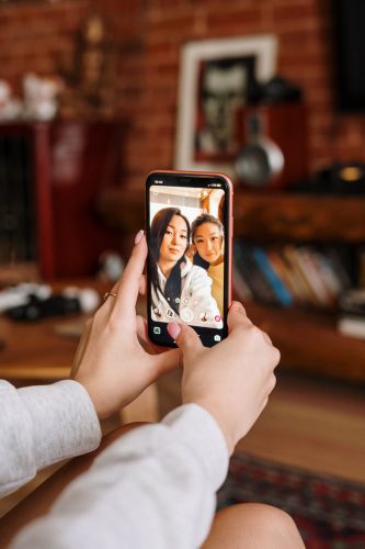 WhatsApp-Speicher. Zwei Personen machen ein Selfie, welches aber nur auf dem Handy sichtbar ist. Bild: Pexels