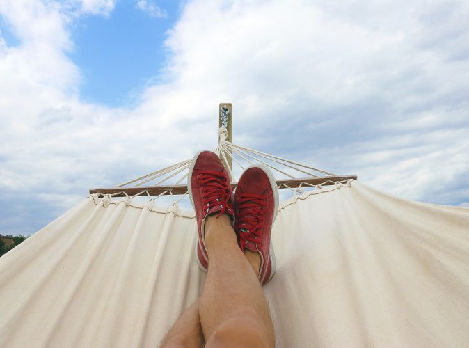 WhatsApp-Urlaubsmodus. Person liegt in einer Hängematte. Nur die Füße sind zu sehen. Bild: Pexels