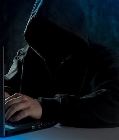 Cybertrading: In schwarz gekleidete Person ohne erkennbares Gesicht vor einem Laptop. Bild: Unsplash/Bermix Studio