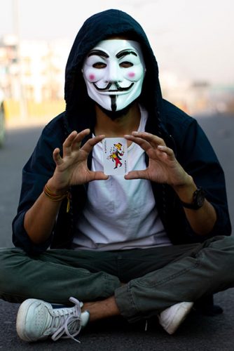 Trojaner Joker: Person hinter Maske vorm Gesicht mit Joker-Spielkarte in der Hand. Bild: Pexels/Ravi Roshan 