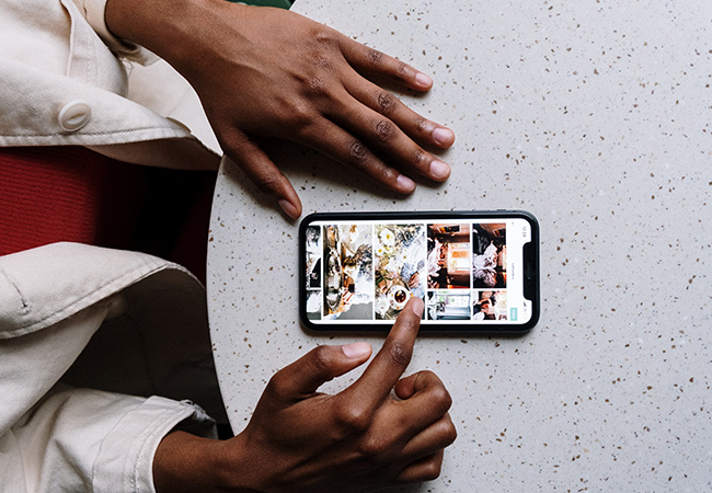 Huawei P50: Handy mit geöffneter Galerie liegt auf einem Tisch zwischen zwei Händen. Bild: Pexels/Cottonbro