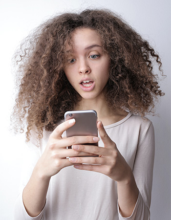 Roaming Mantis: Junge Frau starrt erschrocken auf ihr Handy. Bild: Pexels/Andrea Piacquadio