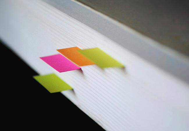 Daten synchronisieren: Dicker Papierstapel mit Lesezeichen. Bild: Unsplash/Chiara F.