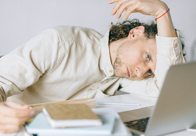 Coron-Burnout: Erschöpfter Mann hängt auf dem geöffneten Laptop. Bild: Pexels/Nataliya Vaitkevich