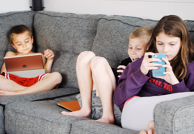 Apple-Abos: Drei Kinder auf einem Sofa, jedes mit einem iOS-Gerät. Bild: Pexels/Jessica Lewis Creative