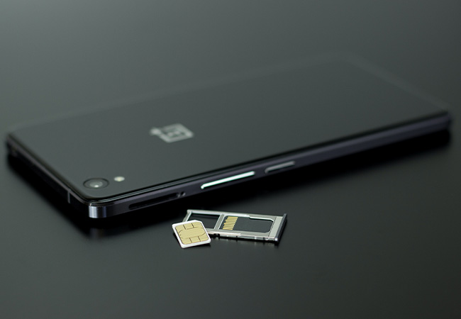 e-SIM: Smartphone mit SIM-Karte auf schwarzem Tisch. Bild: Pexels/Silvie Lindemann