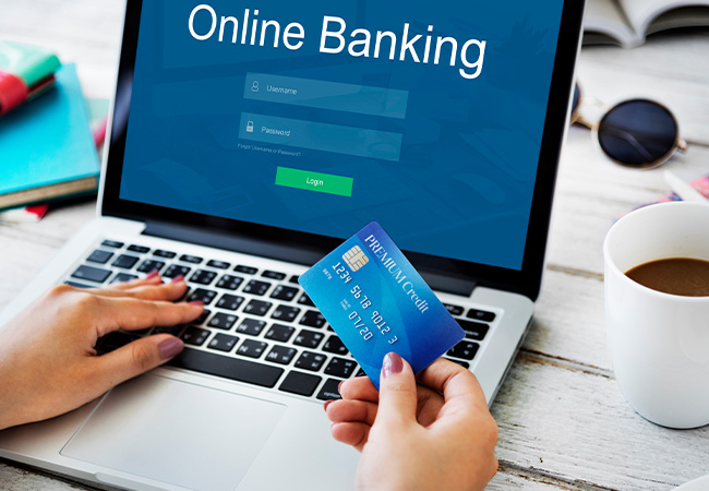 TAN-Verfahren: Frau mit Kreditkarte in der Hand sitzt am Laptop und nutzt Online-Banking. Bild: Rawpixel.com/stock.adobe.com