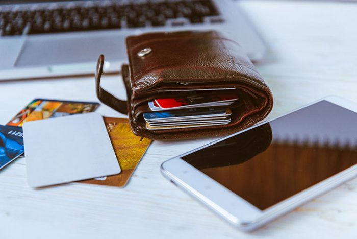 Google Wallet: Laptop, Brieftasche, Brille, Bankkarten und Telefon auf Holztisch Bild: phpetrunina14/stock.adobe.com