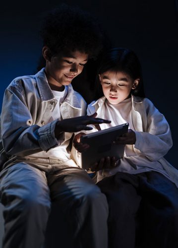 Cyber Resilience: Zwei Kinder spielen nachts am Tablet. Bild: Pexels/Ron Lach