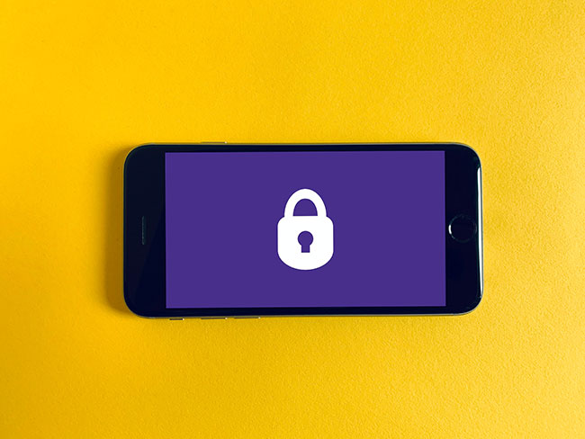 Passkeys: Smartphone mit Schlosssymbol vor gelbem Hintergrund. Bild: Unsplash/Franck