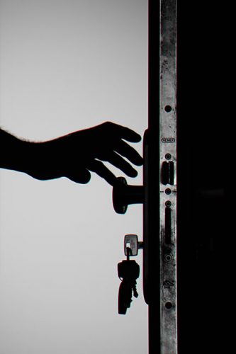 Office-Sicherheitslücke: Schwarz-weiß Bild, Person öffnet verschlossene Tür. Bild: Pexels/George Becker