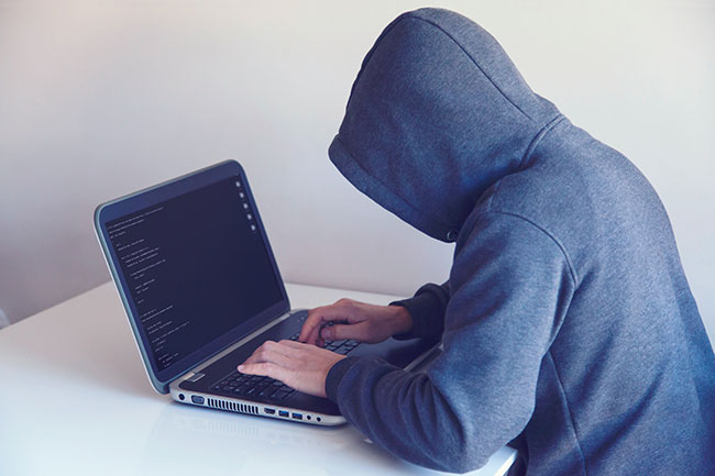 Passwörter verwalten: Person, versteckt unter Hoodie, Seitenansicht, am Laptop. Bild: Pexels/Nikita Belokhonov
