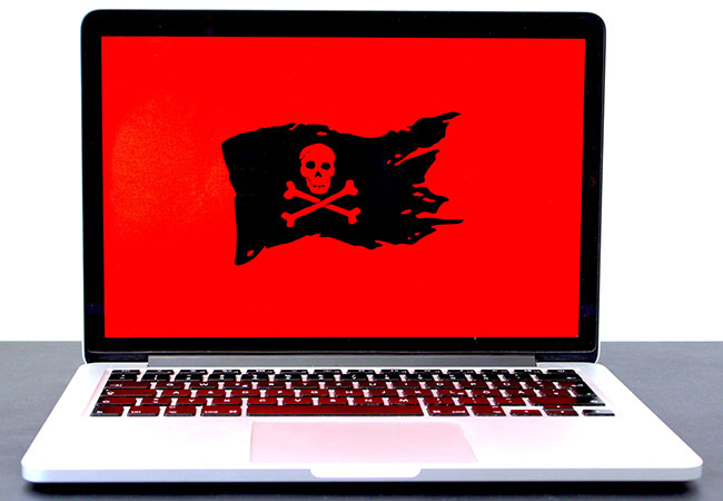 Ransom Cartel: Laptop mit Piratenflagge auf einem roten Bildschirm symbolisiert Hinweis auf Hackerangriff. Bild: Unsplash/Michael Geiger 