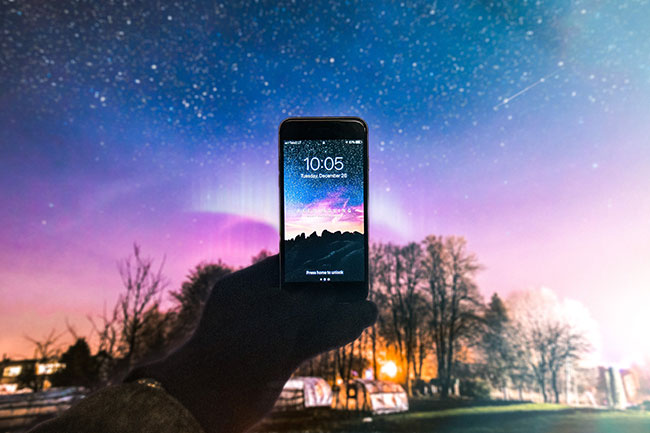 Sternbilder erkennen: Handydisplay in den Nachthimmel gerichtet. Bild: Pexels/Jonas Svidras