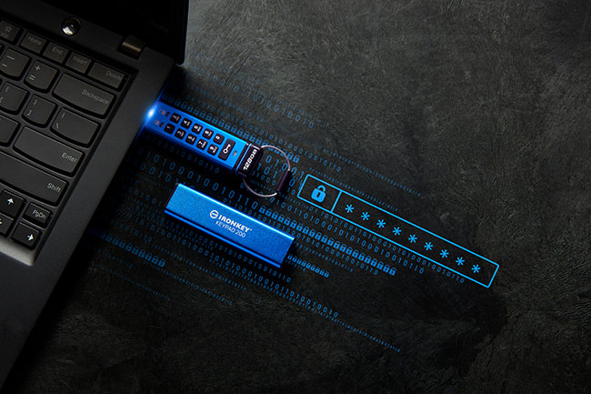 Kingston IronKey Keypad 200: Stick steckt im Laptop, Hülle liegt daneben, Sicherheit wird durch Verschlüsselungscode symbolisiert. ©Kingston