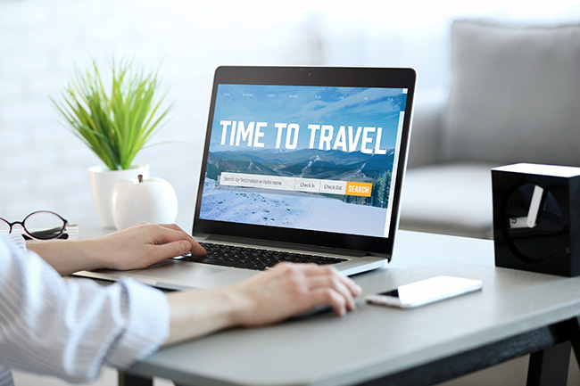 Urlaub 2023 planen: Frau mit Laptop zur Urlaubsplanung. Bild: ©Africa Studio/stock.adobe.com