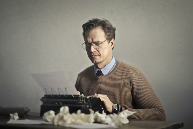 Bundescloud: Mann mit gerunzelter Stirn tippt auf Schreibmaschine, Papiermüll. Bild: Pexels/@olly