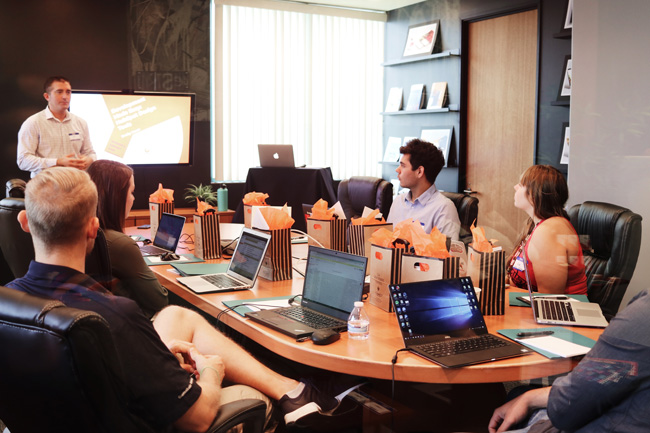 Cactus: Firmenmitarbeiter mit Laptops in einem Konferenzraum. Bild: Unsplash/Campaign Creators