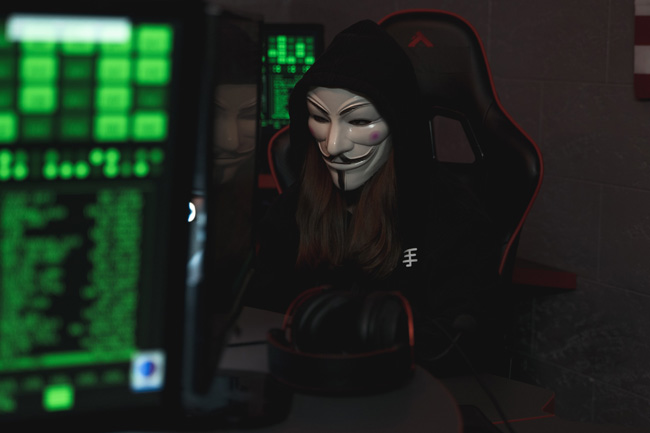RTM-Locker: mit Maske vermummte Person am Computer. Bild: Pexels/@tima-miroshnichenko