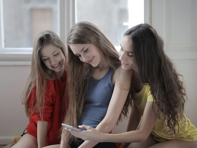 Netiquette: Drei junge Frauen, Freundinnen, surfen auf Smartphone im Internet. Bild: Pexels/Andrea Piacquadio (https://www.pexels.com/de-de/foto/frohliche-freundliche-frauen-die-zusammen-zu-hause-im-internet-auf-dem-smartphone-surfen-3795309/)