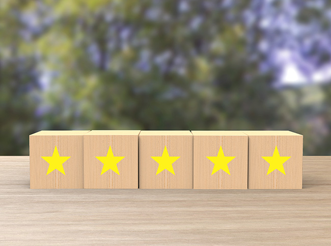 Google-Bewertung abgeben: Fünf Holzwürfel, jeweils mit einem gelben Sternen symbolisieren die Google-Bewertung. Bild: stock.adobe.com/Andrea (https://stock.adobe.com/de/images/wooden-cube-five-yellow-gold-star-review-on-blur-trees-background-service-rating-satisfaction-concept-reviews-and-comments-google-maps-tripadvisor-facebook-online-evaluations/294827067?asset_id=294827067)