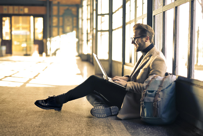 Mann im Blazer sitzt mit seinem Laptop auf dem Boden und arbeitet. Bild: Pexels/Andrea Piacquadio (https://www.pexels.com/de-de/foto/mann-mit-grauem-blazer-838413/)