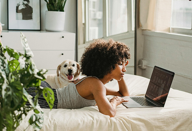 Frau liegt auf dem Bett, stützt ihren Kopf auf die Hand und schaut in ihren Laptop. Bild: Pexels/Samson Katt