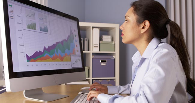 Excel-Formeln: Frau am Computerbildschirm mit einer Excel-Auswertung. Bild: stock.adobe.com/rocketclips (https://stock.adobe.com/de/images/hispanic-businesswoman-working-overtime/86786898?asset_id=86786898)