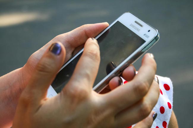 Nummer blockieren: nicht erkennbare Person hält weißes Samsung-Handy in der Hand. Bild: Pexels/John-Mark Smith (https://www.pexels.com/de-de/foto/menschliche-hand-halt-weiss-samsung-duos-android-smartphone-211681/)