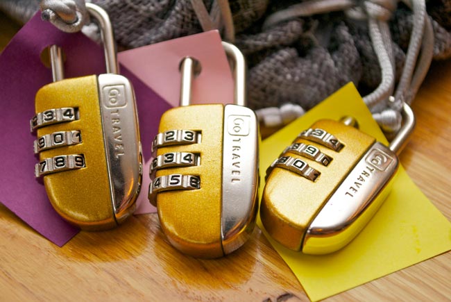 Ordner mit Passwort schützen: Drei gelbe Zahlenschlösser an buntem Papier. Bild: Pexels/Laura Gigch (https://www.pexels.com/de-de/foto/drei-gold-silber-kombinationsvorhangeschlosser-943922/)