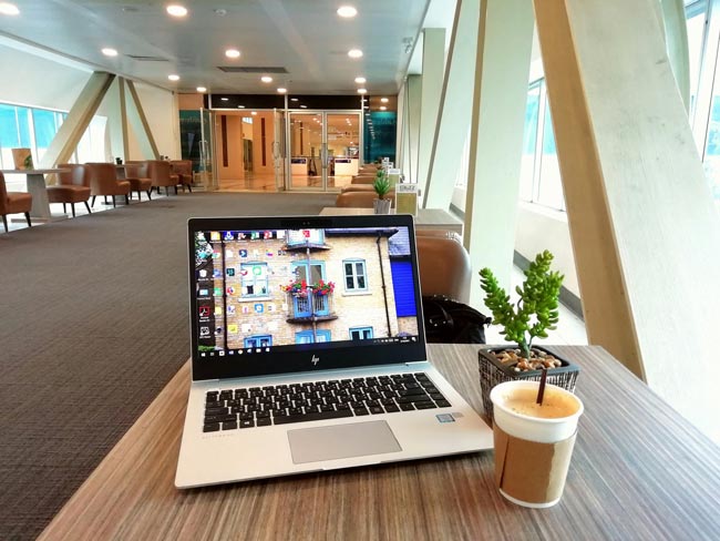 Geöffneter Laptop mit buntem Bildschirmhintergrund auf einem Tisch in einem großen Raum. Bild: Pexels/Sirinda Ins (https://www.pexels.com/de-de/foto/schwarzer-und-silberner-laptop-computer-1477284/)