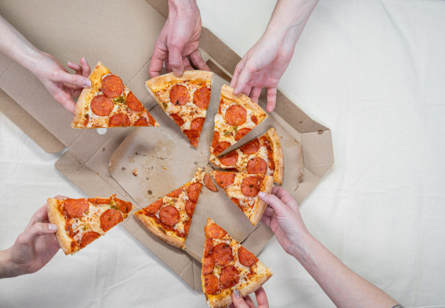 Sharing Economy: Hände greifen zur Pizza und jeder nimmt sich ein Stück. Bild: Pexels