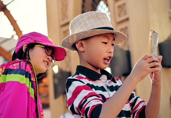 Kinder-Selfies: Zwei Kinder mit einem Smartphone. Bild: Unsplash/tim gouw