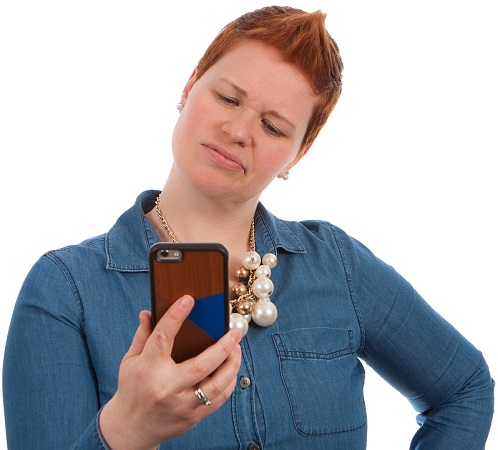 Frau schaut abschätzend auf Ihr Handy. Vielleicht prüft sie ihre Android-Einstellungen. (Bild: pixabay.com/NDE)