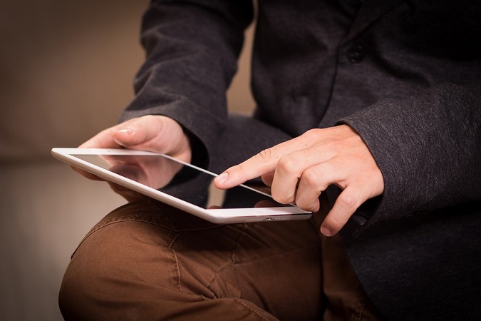 Junger Mann arbeitet mit einem iPad. Vielleicht benutzt er gerade eine Bildbearbeitungsapp? (Bild: pixabay.com/niekverlaan)