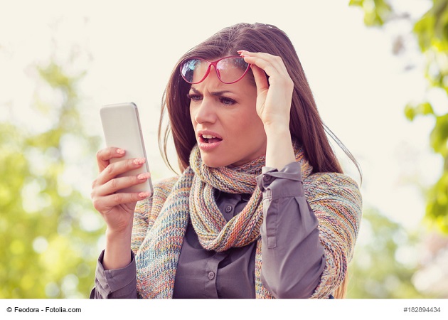 Junge Frau schaut erschrocken auf ihr Handy. Ob sie einen Handy-Virus hat?. Foto: Fotolia/©Feodora