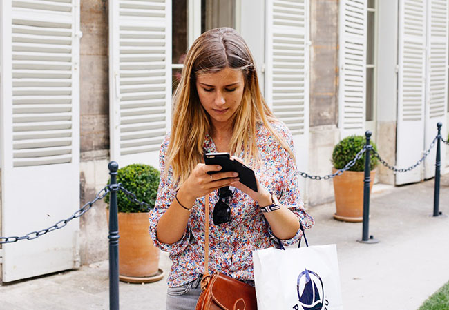 Was ist Smishing? Junge Frau beim Shoppen und Handy in der Hand. Bild: Pixabay